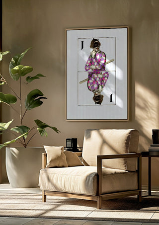 Joker by Bent Hardervig framed above a beige armchair beside a potted plant