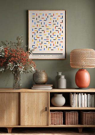 Bauhaus Dashes by Neil Stevens above a wooden sideboard on a sage green wall