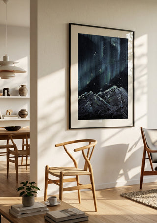 Aurora by Zhan Snow in a black frame in a bright dining room with wooden chairs