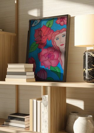 The watching Eye by Carmen Coduri in a dark frame on a wooden shelf beside books and a lamp
