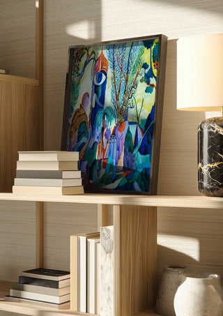 Otono by Carlos Enrique Gozalo Ara in a dark frame on a wooden shelf beside books and a lamp