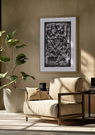 Black Field by David Pernecker framed above a beige armchair beside a potted plant