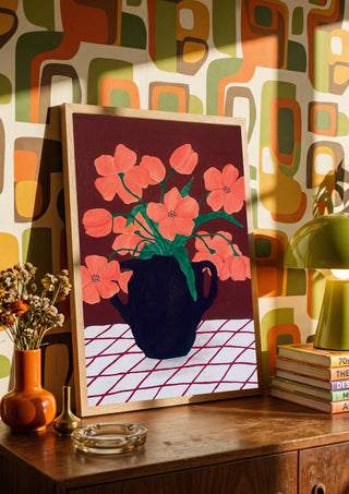 Rosa blomster på rutig duk by Rebecka Hansson in a wooden frame on a sideboard against a retro patterned wall
