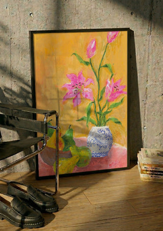 Lillies by Deblina Dey in a black frame leaning against a concrete wall by a steel chair