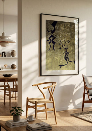 Whispers in Gold by Bibi in a black frame in a bright dining room with wooden chairs