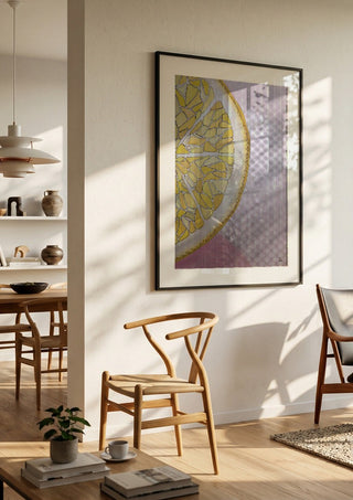 Lemon Slice by L.OE. Art in a black frame in a bright dining room with wooden chairs