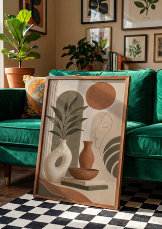 Earth Tone Abstract Still Life by TimlessArtworks in a wooden frame beside a green velvet sofa on a chequered floor