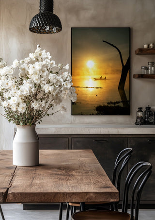 Fishermen Of Naivasha by Gloria Mwivanda in a black frame above a rustic table with white flowers