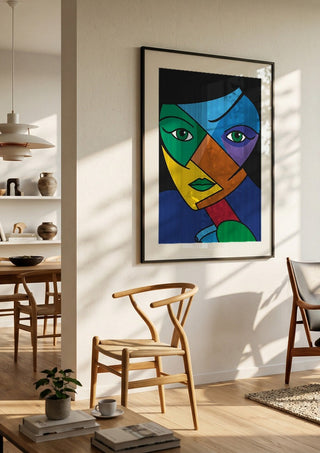 Mosaic of the Psyche by Bibi in a black frame in a bright dining room with wooden chairs
