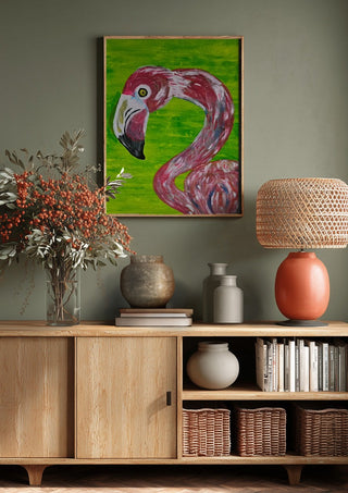 Vibrant Flamingo by Bibi above a wooden sideboard on a sage green wall