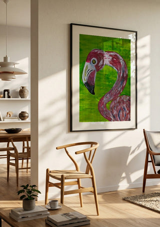 Vibrant Flamingo by Bibi in a black frame in a bright dining room with wooden chairs