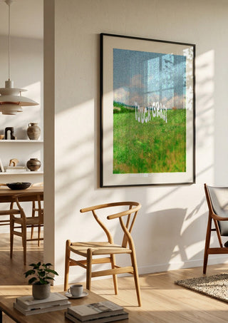 Touch Grass by Jakob Falkenberg in a black frame in a bright dining room with wooden chairs