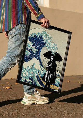 Under the wave by Dikhotomy carried in a black frame along a sunny street