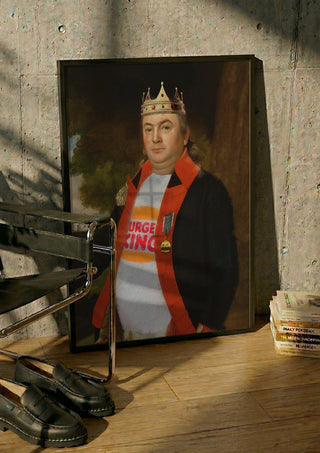 Fast Food King by Dikhotomy in a black frame leaning against a concrete wall by a steel chair