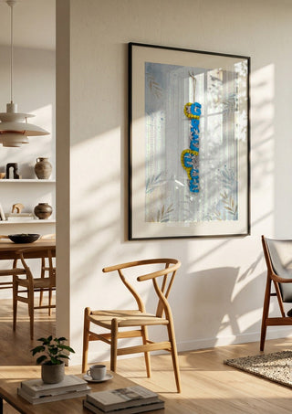 GREECE Terracotta by Ammar in a black frame in a bright dining room with wooden chairs