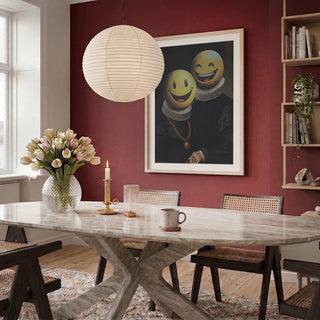 Framed artwork "The Smilers - Dikhotomy" displayed on a red wall in a modern dining room setting.