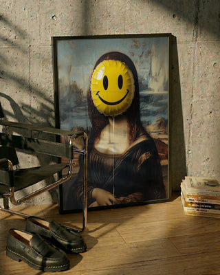 Framed Mona Lisa parody with a yellow smiley face balloon covering her head, on floor near chair and books.