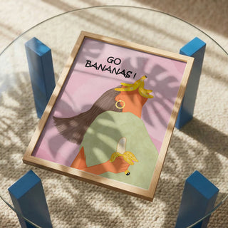 Framed Go Bananas Playful art print by Sannel Larson on a glass table, depicting a woman holding bananas.