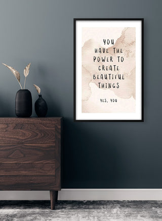 Framed "You Have The Power" poster on a dark wall above a wooden dresser with vases and dried grasses.