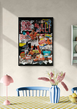 Framed Muhammad - Ricardo Noble artwork displayed on a light wall above a dining table with flowers.