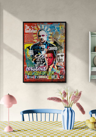 Framed "Poderoso" art print by Ricardo Noble featuring colorful portraits, displayed above a dining table.