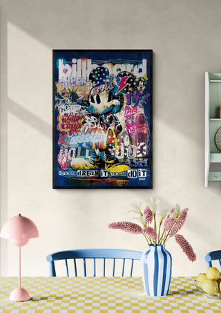 Framed Mickey - Ricardo Noble art print on a wall above a dining table with flowers and modern decor.