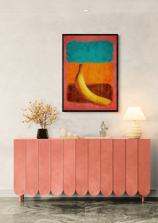 Abstract banana art print "Rothko Goes Bananas" by Martin Zen hanging above a coral sideboard in a modern room.