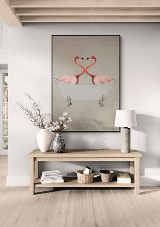 Art print of two flamingos in a bathtub, displayed above a wooden console table with decor items.