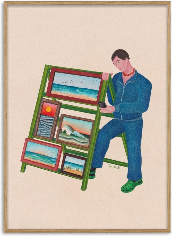 Seaside side hustle by Daukantė, a man on his phone beside a green stall of small framed seascapes